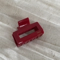 Detailed close-up of a glossy wine red rectangular hair claw with gold FRANCE handmade text - Red
