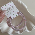 Detail of light purple spiral hair ties with floral patterns on a display card - Light Pink Thin