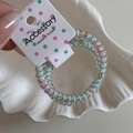 Detail of floral pattern telephone wire hair coil held on a white Accessory card tag - Light Blue Thin