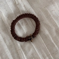 Dettaglio dello scrunchie marrone scuro con ciondolo a stella stampa leopardata - Caffè Lega Leopardo Stella