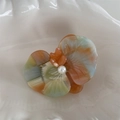 Detail of orchid acetate hair clip with pearl and bear center on a ceramic plate - Blue Green Orange