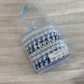 Detail of woven elastic hair bands in light and dark blue shades inside a clear box - Blue