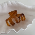 Dettaglio macro della molletta per capelli in acetato tartarugato con incisione a mano - Marrone