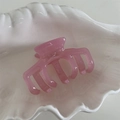 Detailed close-up of pink acetate hair claw with France Handmade text on white shell tray - Pink