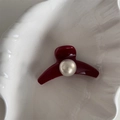 Dettaglio di un fermaglio per capelli rosso con perla grande su un vassoio a conchiglia - Rosso Borgogna Perla - Arco