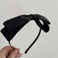 Close-up of a stylish double-layer black fabric bow headband with a sleek metal base - Black