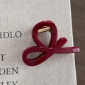 Detailed view of the dark red cross-knot hair claw clip with a glossy finish and gold spring - Gold Glitter Red - Cross Knot