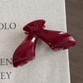 Detailed view of glossy burgundy red hair claw clip with high-shine finish on fabric - Gold Glitter Red - Arch Bridge