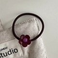 Haargummi mit tiefroter Harzblume und lila Perle auf elastischem Band vor Leinwand - Haargummi / Lila