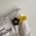 Handgefertigte gelbe Acetat-Haarklammer mit schwarzer Blume auf beigem Canvas - Haarclip / Dunkles Blaugrün