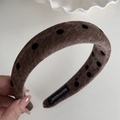Gros plan détaillé du serre-tête en velours à pois avec étiquette faite à la main en tissu - Serre-tête / Café Foncé
