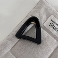 Detailed macro view of a glossy black triangle hair claw clip with golden metal spring - Thin Triangle Black