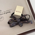 Detalle de pinza para el pelo con lazo de tela floral rosa y amarilla sobre fondo gris - Coletero Lazo Floral - Gris