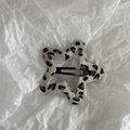 Close-up of star-shaped hair clip with leopard print fabric and black metal snap clip - White Leopard Star