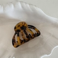 Detail of tortoiseshell patterned acetate hair claw clip on white textured tray - Dark Leopard