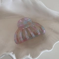 Close-up of hollow shell hair claw clip with colorful marble acetate texture on shell tray - Iridescent Blue Pink