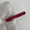 Detail of glossy deep red acetate barrette featuring elegant Barrette la France script lettering - Red