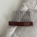 Detail eines handgefertigten Acetats-Haarkamms mit Gravur und 11 Metallzinken für Damen - Braun