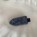 Détail d'une pince à cheveux en velours bleu foncé avec trois nœuds argentés - Pince à Bec de Canard avec Nœud en Tissu Bleu