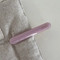 Close-up of purple acetate hair clip featuring gold lettering on cream canvas - Pink