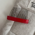 Nahaufnahme eines roten Haarkamms aus Acetat mit Handmade France-Schriftzug auf Leinen - Glänzendes Rot