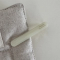 Detail showing mint green acetate barrette with Barrette La France text on linen - Cream