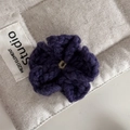 Detailaufnahme der dunkelvioletten, handgehäkelten Blumen-Haarklammer aus dicker Wolle - Lila