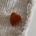 Vista macro de la mini pinza para el pelo de acetato ámbar con grabado dorado francés - Café claro
