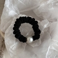 Primer plano de un coletero negro brillante con una gran perla decorativa blanca - Negro