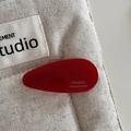Close-up of red acetate water drop hair clip with gold France Handmade lettering - Red