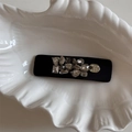 Gros plan sur une barrette en satin noir avec strass et pendentif en argent gravé - Grande Pince à Cheveux Rectangulaire en Strass