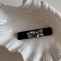 Détail d'une barrette en velours avec strass brillants dans un plat en céramique - Petite Pince à Cheveux Rectangulaire en Strass