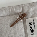 Close-up of brown bow hair clip with white polka dots on textured linen fabric - Light Coffee