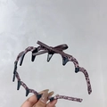 Détail du serre-tête léopard rose avec nœud en cuir marron et pinces à cheveux - Bandeau à Dents Léopard Rose