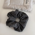 Primer plano de diadema de tela de tweed blanca y negra sobre fondo de lino minimalista - Coletero / Mezcla de Blanco y Negro