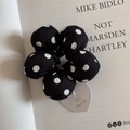 Close-up of black and white polka dot flower scrunchie with a heart-shaped tag charm - Black With White Polka Dots Style