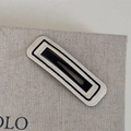 Dettaglio della molletta per capelli in pelle bicolore con cuciture e design traforato - Base Bianca Linea Nera - Rettangolo