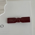Dettaglio di fermaglio per capelli a fiocco rosso scuro con scritte dorate - Rosso-Fiocco
