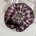 Close-up of vintage plaid hair scrunchie with a black bow and engraved gold button detail - Red Green Plaid Scrunchie With Black Ribbon