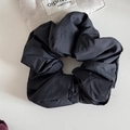 Close-up of black oversized pleated scrunchie with soft matte texture for hair styling - Black