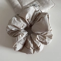 Macro detail of creamy beige oversized scrunchie showing pleated fabric texture and soft folds - Beige