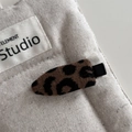 Dettaglio macro della molletta per capelli leopardata con base in metallo nero vintage - Stile Clip Senza Segni in Tessuto Leopardato