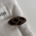 Macro shot of large leopard print hair claw clip on neutral linen texture background - Leopard Fabric Chunky Oval Style