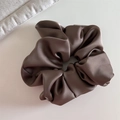 Detalle de un coletero grande de satén bronce con elegante textura de tela plisada - Café Oscuro