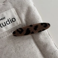 Detail view of a leopard print fabric hair clip on neutral canvas background - Leopard Fabric Long Oval Style