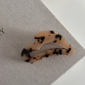 Macro shot of French acetate heart-shaped hair claw clip with classic amber tortoiseshell texture - Tortoise