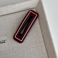 Close-up of a burgundy leather star hair clip with white piping and neat stitching - Rectangular White Border Style
