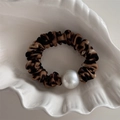 Dettaglio dell'elastico scrunchie leopardato con una grande perla bianca su guscio - Stampa Leopardata Scura Perla Artificiale