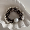 Gros plan sur chouchou léopard avec bordure en dentelle blanche et détail grande perle - Léopard Clair Dentelle Perle