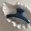 Detail view of a navy blue hair claw with red polka dots placed in a shell plate - Mist Blue Red Dot (Straight)